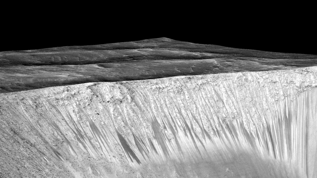 Учёные называют такие тёмные полосы recurring slope lineae. Здесь показаны полосы кратера Гарни на Марсе. Длина каждой полосы порядка нескольких сотен метров. Теперь учёные считают, что они сформированы водой