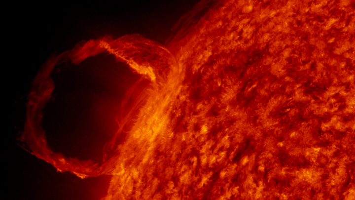 Массивное волокно плазмы, вырвавшейся на поверхность Солнца. Плазма течёт по петле вдоль силовой линии магнитного поля.